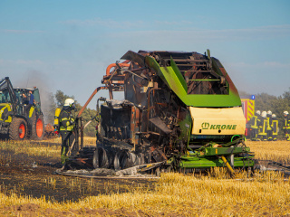Rundballenpresse brennt auf Getreidefeld - Feuerwehren und Landwirte verhindern Ausbreitung